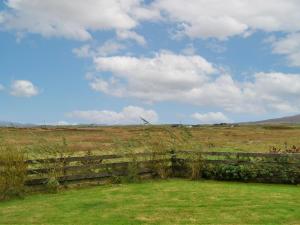 a fence in the middle of a field at Taigh Violet Rose in Gramisdale +4 photos