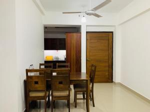 a dining room with a wooden table and chairs at Urban View by CityScape in Colombo