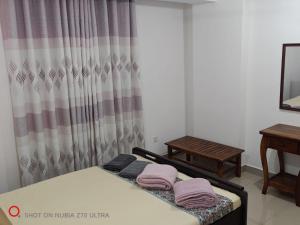 a bedroom with two beds with pink towels on them at Urban View by CityScape in Colombo