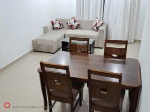 a living room with a table and chairs and a couch at Urban View by CityScape in Colombo +1 photo