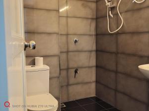 a bathroom with a shower and a toilet and a sink at Urban View by CityScape in Colombo
