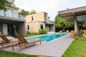 a backyard with a pool and two chairs and a house at Cala Laiya in San Juan