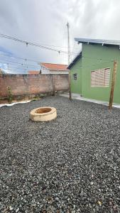 a house with a wooden seat in a gravel driveway at Canastra House in Delfinópolis +2 photos