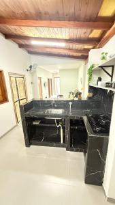 a black bathroom with a sink and a stove at Canastra House in Delfinópolis
