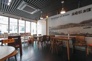 a restaurant with tables and chairs and a large mural at 다락방친구들 in T'ongyŏng