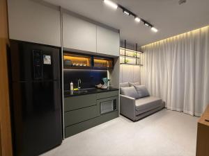 a kitchen with a sink and a chair in a room at Sky Designer Alphaville - 1611 in Barueri