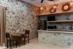 a kitchen with stone walls and a table and chairs at Villa Carulio in Ebtún +10 photos