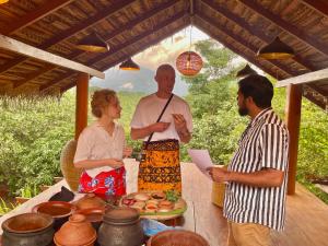 a group of people standing around a table at Heaven's Acres Lodge - Private one Bedroom Cabana in Matale