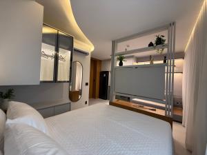 a bedroom with a bed and a flat screen tv at Sky Designer Alphaville - 1611 in Barueri +38 photos