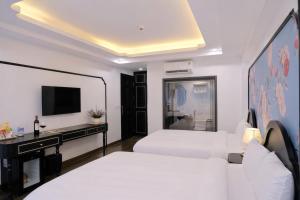 a hotel room with two beds and a television at Stella De Boutique Hotel in Sapa
