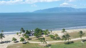 an aerial view of a beach with a house and palm trees at Condomínio Vila Gustavo excelente localização in Caraguatatuba