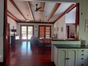 a kitchen with a ceiling fan and a living room at Forest Edge Cottage Dwellingup in Dwellingup