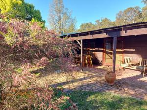a porch of a house with a table and chairs at Forest Edge Cottage Dwellingup in Dwellingup