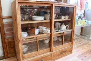 a wooden cabinet filled with dishes and cups at イトノ-itono- in Goto