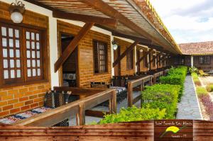 an outdoor patio with benches and a brick building at Hotel Fazenda Ceu Aberto in Gravatá