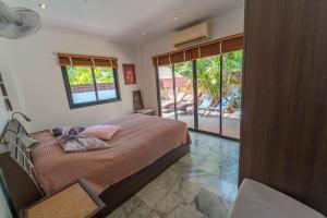 a bedroom with a bed and a large window at Malee Beach C6 in Phra Ae beach