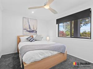 a bedroom with a bed and a ceiling fan at Iluka Magic in Iluka