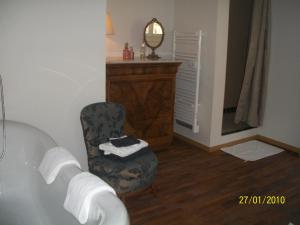 La salle de bains est pourvue d'une chaise et d'une baignoire. dans l'établissement L'Orangerie, à Rivesaltes