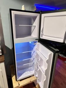 an empty refrigerator with its door open in a kitchen at MidwestBNB Room1, quite cabin in the wood vibes in Minneapolis