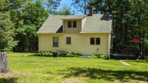 a yellow house in a yard with a tree at Yellow Barn House in Danbury