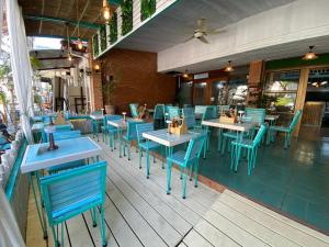 an empty restaurant with blue tables and chairs at La Vida Hostel Chiang Mai in Chiang Mai