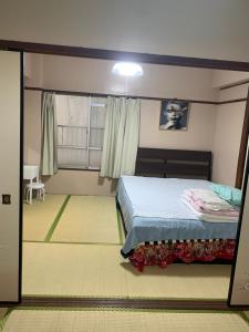 a bedroom with a bed and a window at 山下ビル403 in Kitakyushu