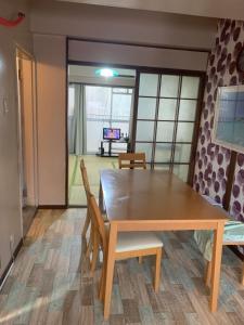 a dining room with a wooden table and chairs at 山下ビル403 in Kitakyushu
