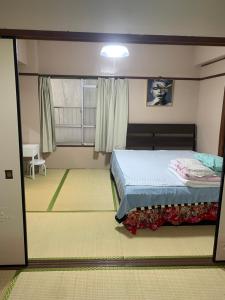 a bedroom with a bed and a window at 山下ビル403 in Kitakyushu