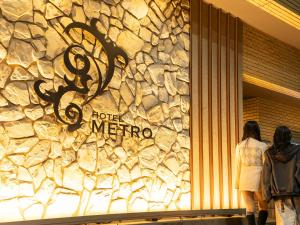 two women standing in front of a store window at Hotel Metro (Adult Only) in Yokohama