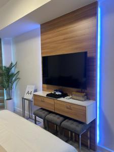 a bedroom with a large entertainment center with a flat screen tv at Mekeni Azure Escape in San Fernando