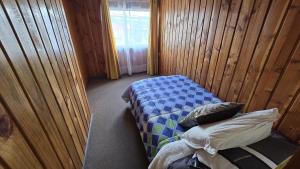 a small room with a bed and a window at San Joaquin in Curacautín