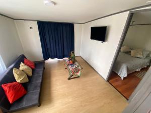 a living room with a couch and a bed at San Joaquin in Curacautín +1 photo