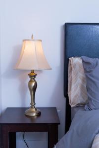 a lamp sitting on a table next to a bed at Honeycomb Suite in Riverview