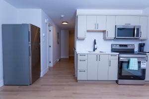 a kitchen with white cabinets and a refrigerator at Honeycomb Suite in Riverview +12 photos