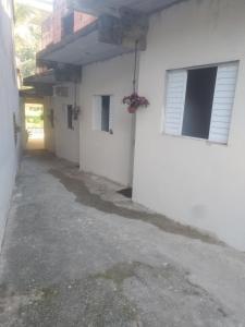 an empty alley next to a white building at chácara Cantagalo in Caraguatatuba