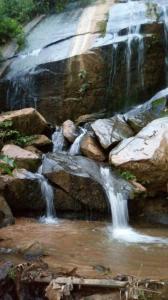 a stream of water in a waterfall with rocks at chácara Cantagalo in Caraguatatuba
