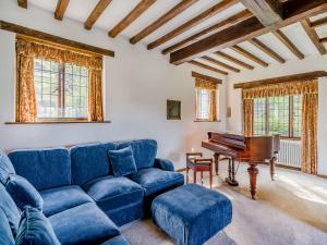 a living room with a blue couch and a piano at High Biggin in Windermere