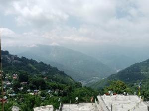 a view of a valley with mountains in the background at ViDi Hotel Serene Point ! Kalimpong in Kalimpong
