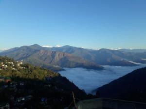 a view of a mountain with clouds in the valley at ViDi Hotel Serene Point ! Kalimpong in Kalimpong