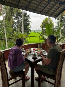 a man and a woman sitting at a table at Rice Rice Villas in Tissamaharama