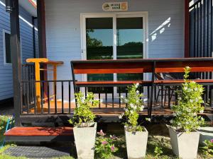 a porch with three potted plants on a house at Mook Raya Resort in Ko Mook