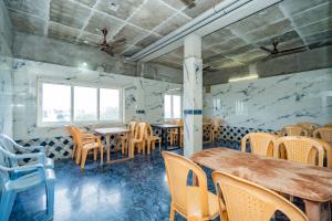 a dining room with tables and chairs and a window at Right choice hotels in Rāmeswaram