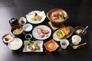 eine Gruppe von Tellern mit Essen auf einem Tisch in der Unterkunft あじ彩の宿小浜荘 in Toba