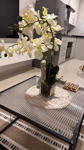 a vase with white flowers on a table in a kitchen at The F402 Residence in Gaborone