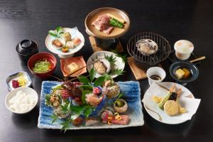 ein Tisch mit mehreren Tellern mit Essen darauf in der Unterkunft あじ彩の宿小浜荘 in Toba