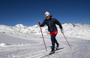 a man is skiing down a snow covered slope at Berghotel Tyrol in Senales