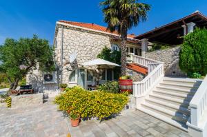 a house with a palm tree in front of it at Villa La Vagabonda in Orasac