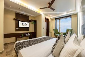 a bedroom with a bed with two chairs and a window at The Vanson Delite "Newly Rebuilt 2026" - Near New Delhi Station & Connaught Place in New Delhi