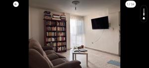 a living room with a couch and a book shelf at Cómoda y céntrica habitación en Tenochtitlán, en departamento compartido, CDMX in Mexico City