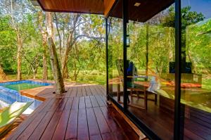 a glass house with a deck and a swimming pool at Raintree Haven in Dambulla +16 photos